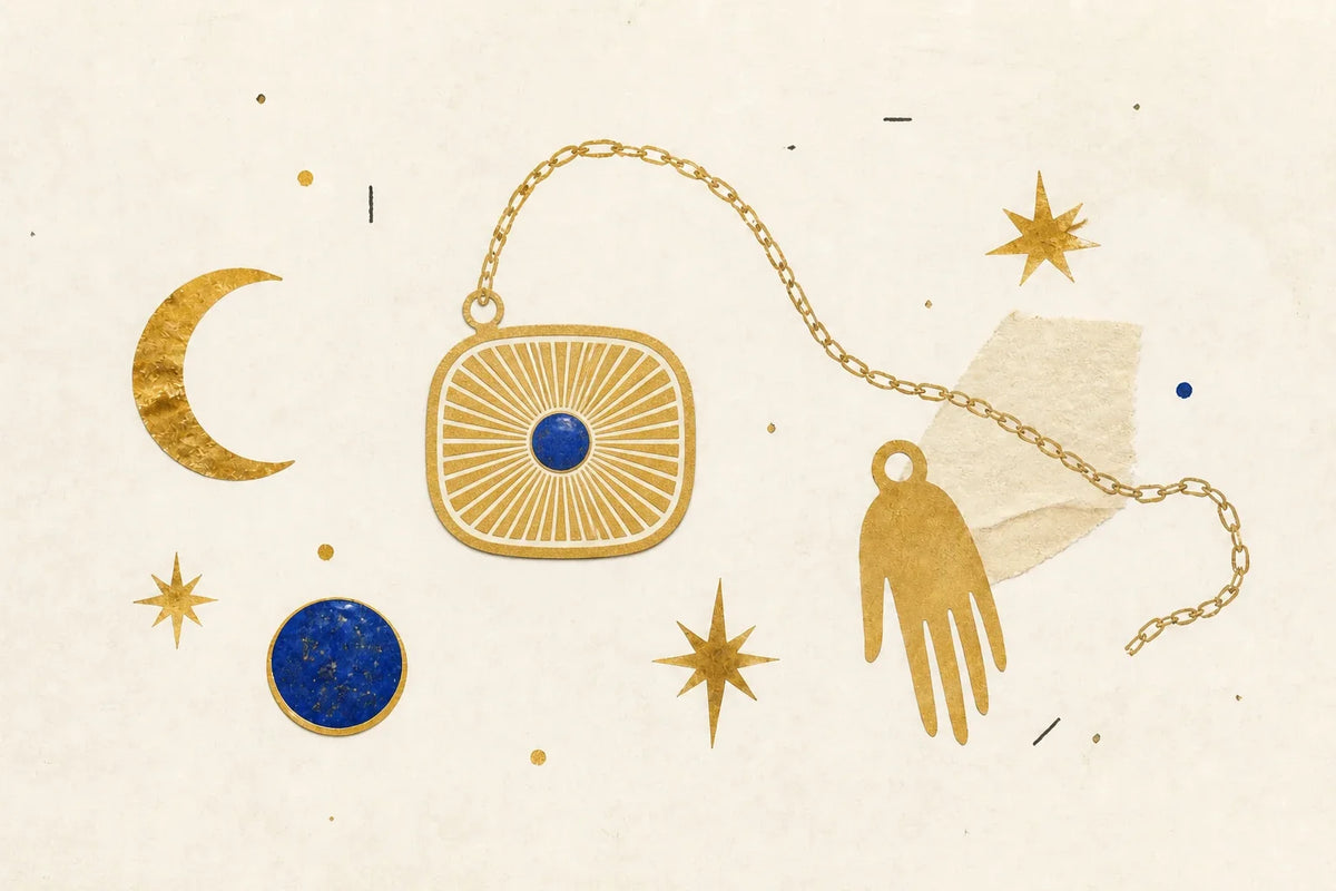 Rounded-square gold sunburst pendant, crescent, stars, hand-shaped charm, and blue stone on ivory paper
