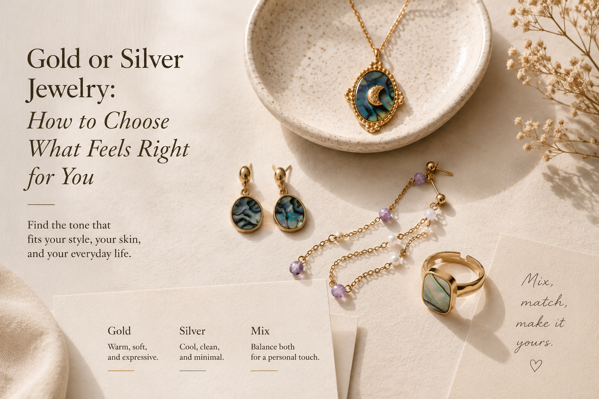 Gold-toned shell jewelry and a lavender bead bracelet arranged on a cream surface