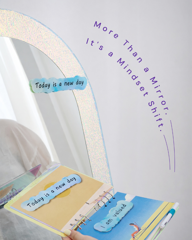 Close-up of iridescent Refi Miro mirror with affirmation magnets and booklet pages reading Today is a new day