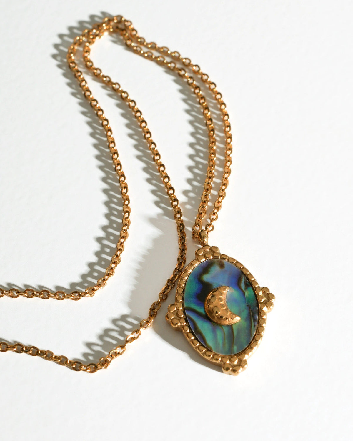 Tidal Stone Pendant Necklace laid flat on a cream background