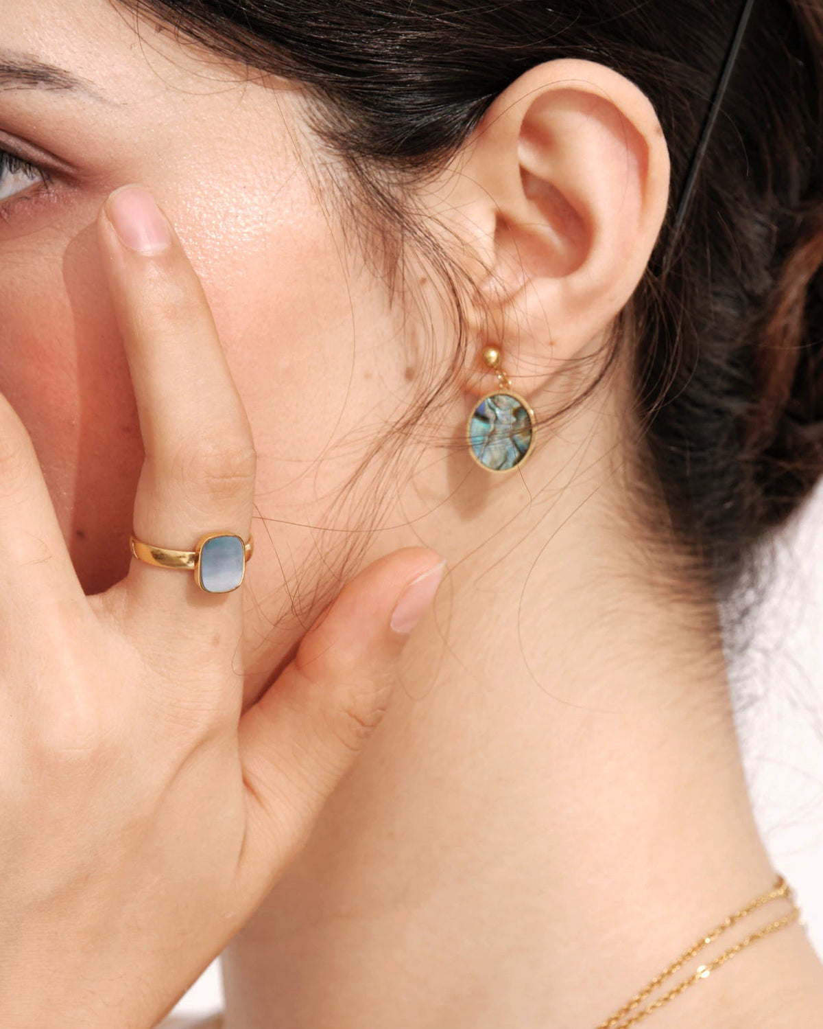 Model wearing Tidal Stone Stud Earrings with a matching shell ring