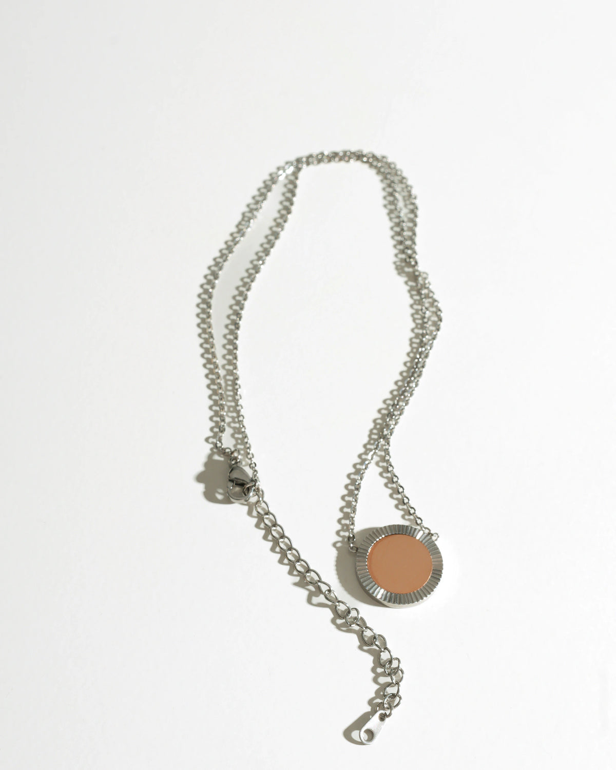 Silver Reflection Pendant Necklace laid flat with its extender chain