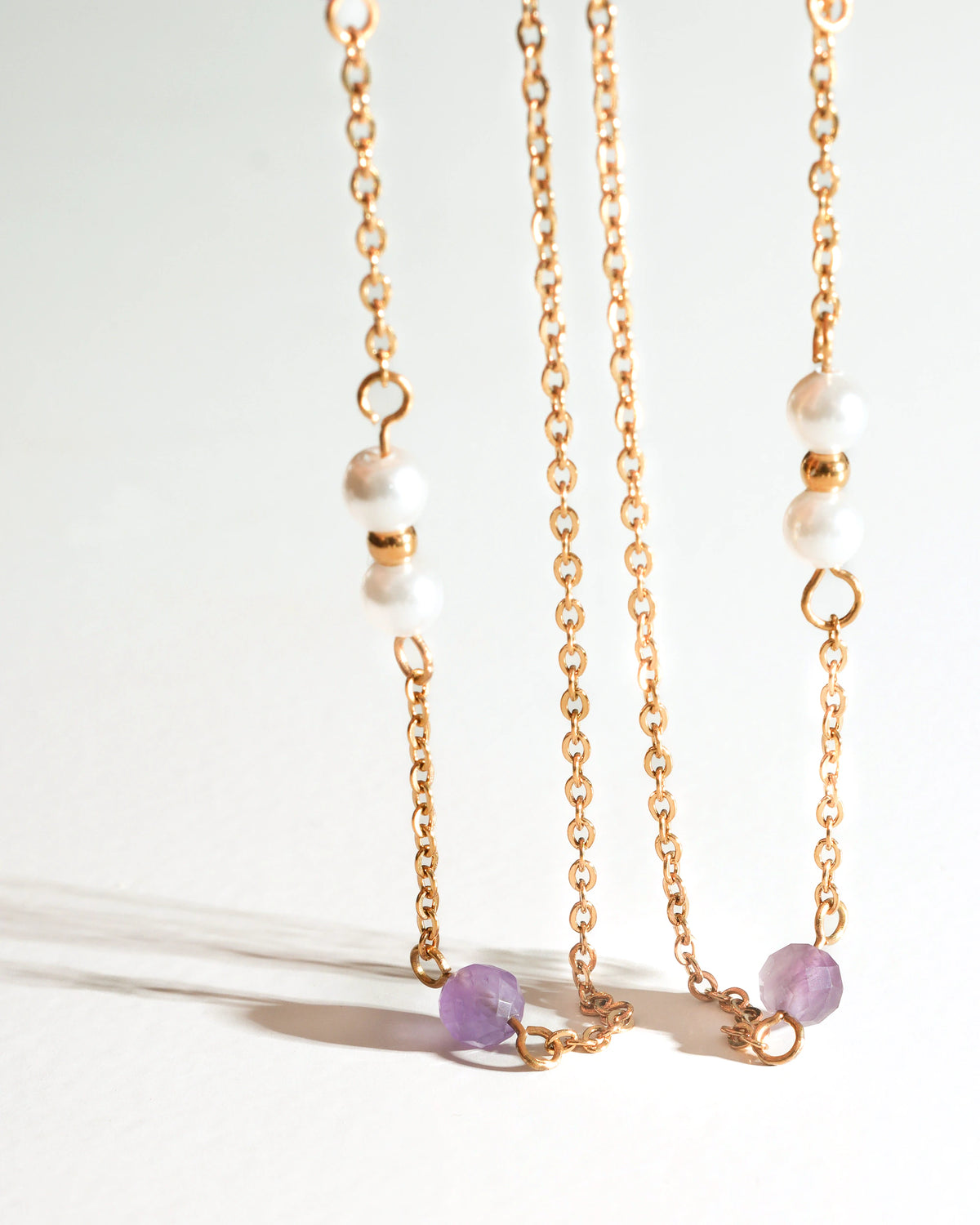 Close-up of Lavender Drift Drop Earrings with purple stones and pearl beads