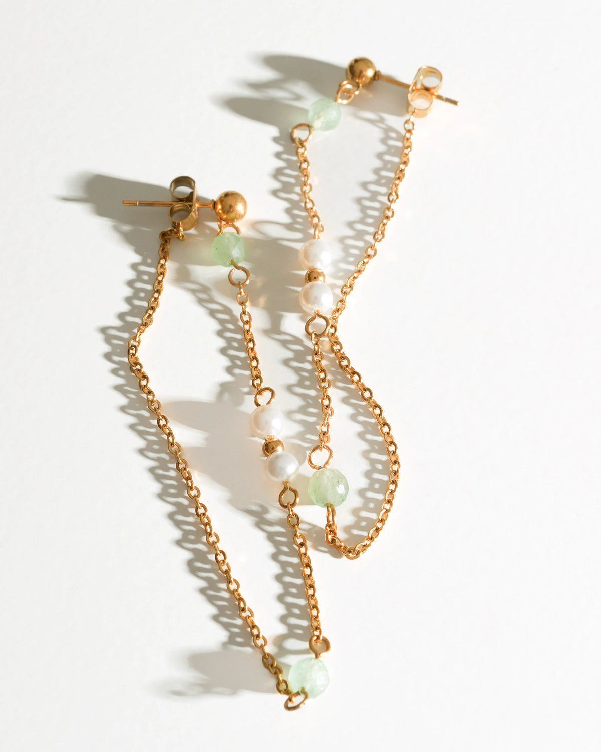 Willow Drift Drop Earrings with pale green stones and pearl beads laid flat