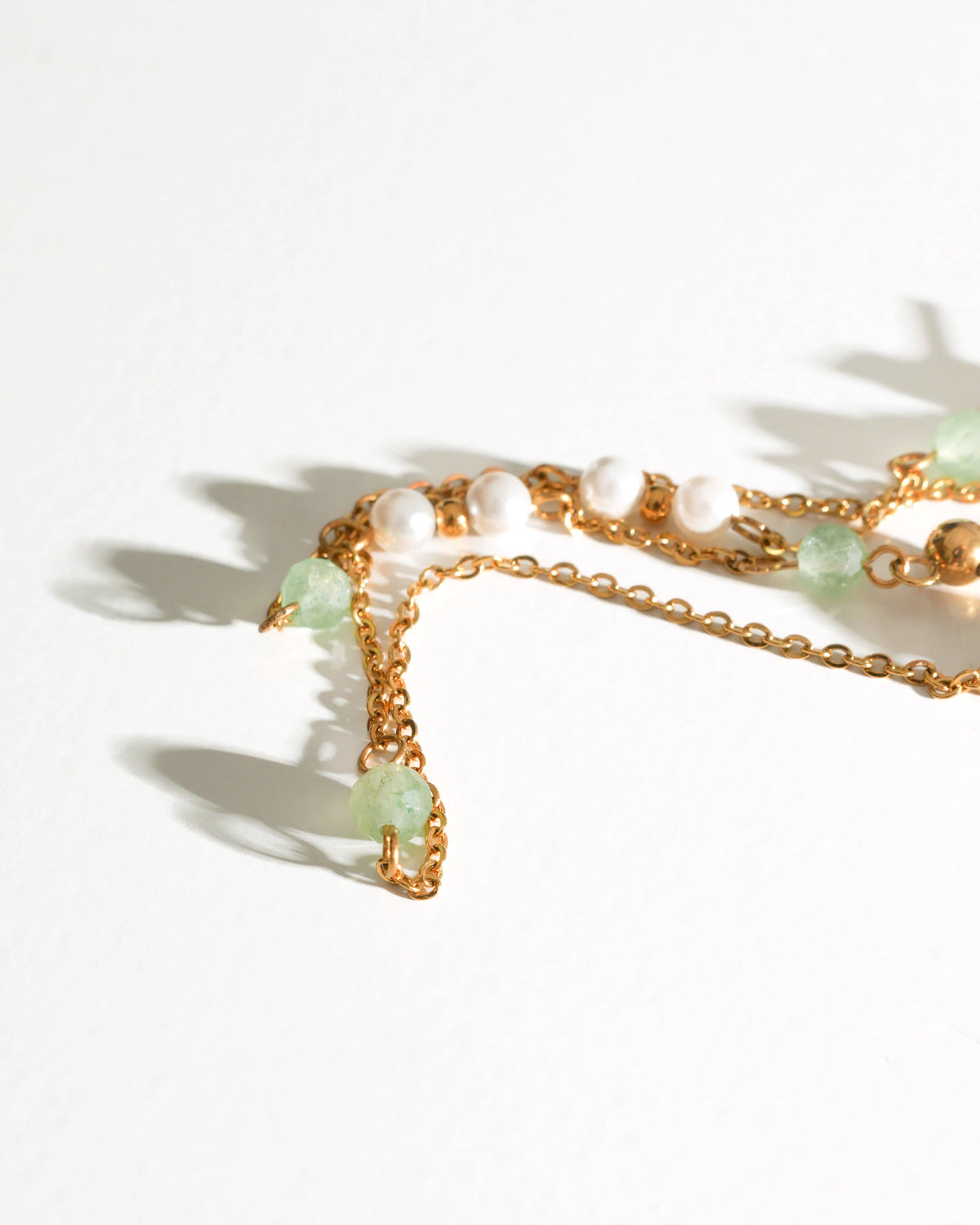 Close-up of Willow Drift Drop Earrings with pale green stones and pearl beads