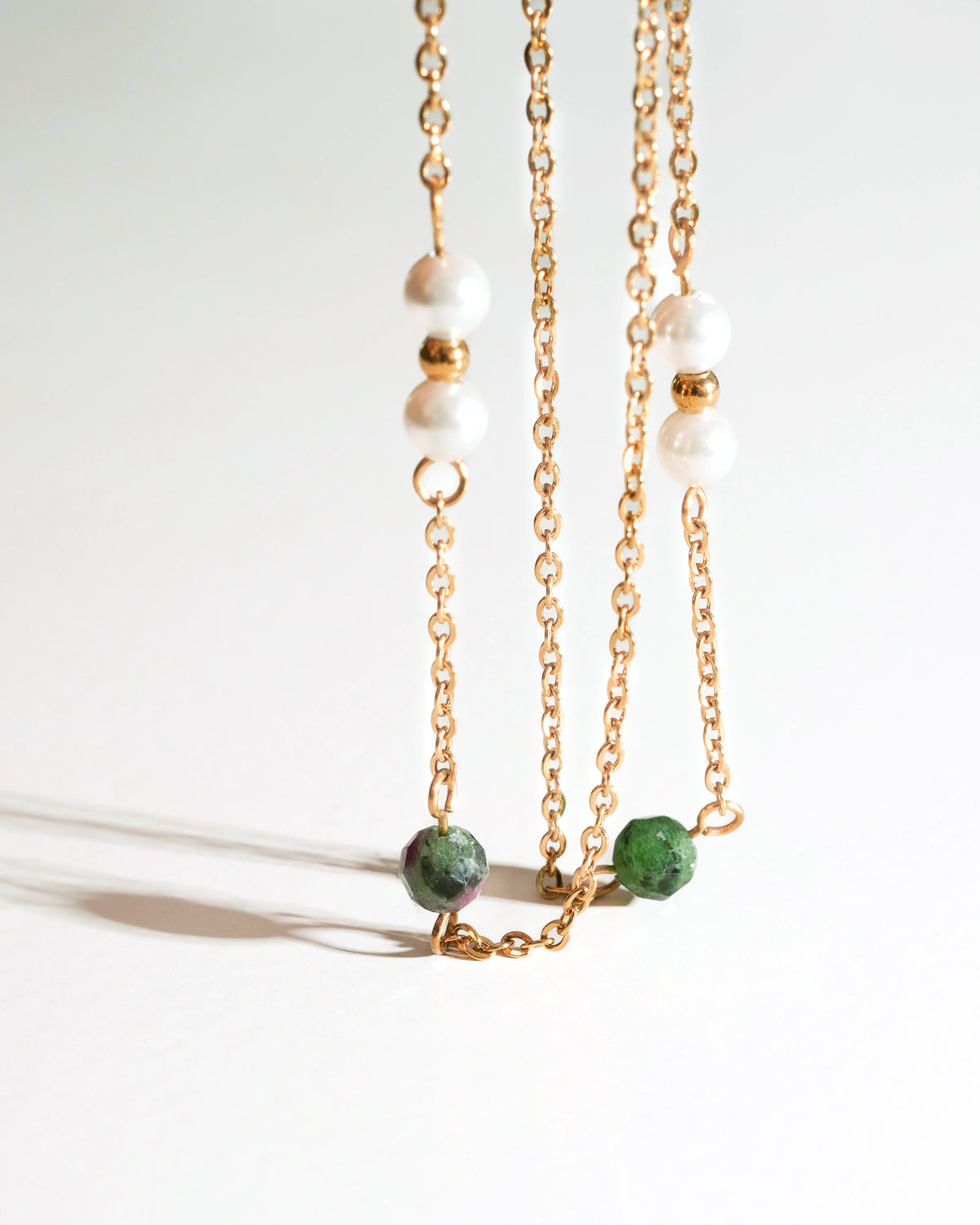 Detail view of Solstice Drift Drop Earrings with green stones and pearl beads