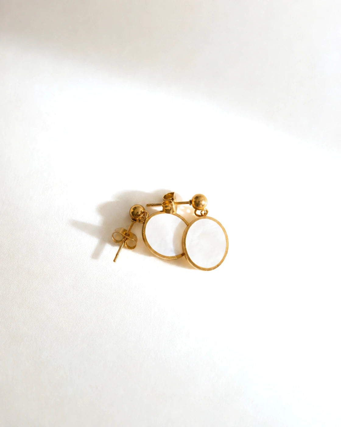 Pair of Tide Stone Stud Earrings arranged side by side in warm sunlight