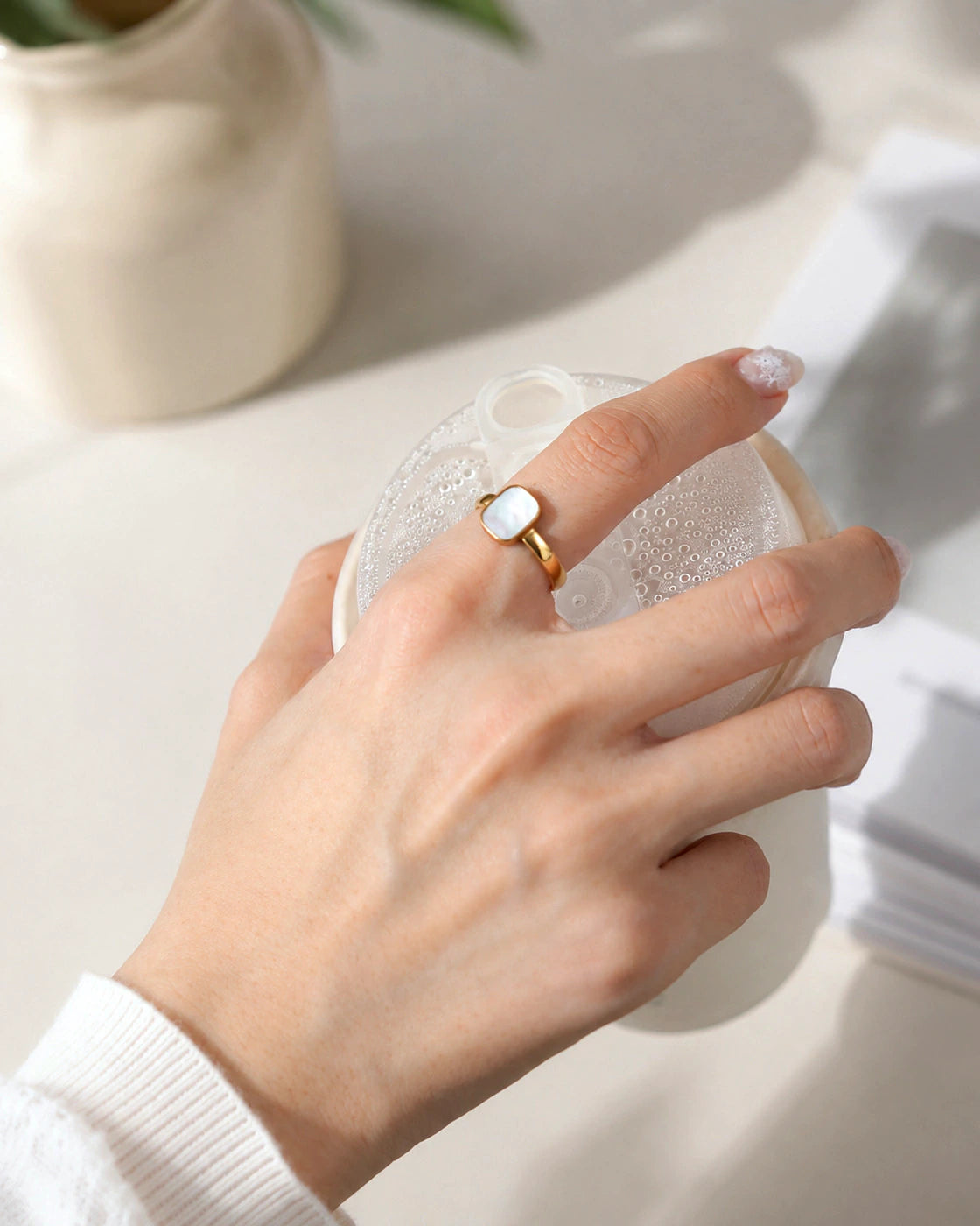 Model wearing the Tide Stone Ring while holding a glass sphere