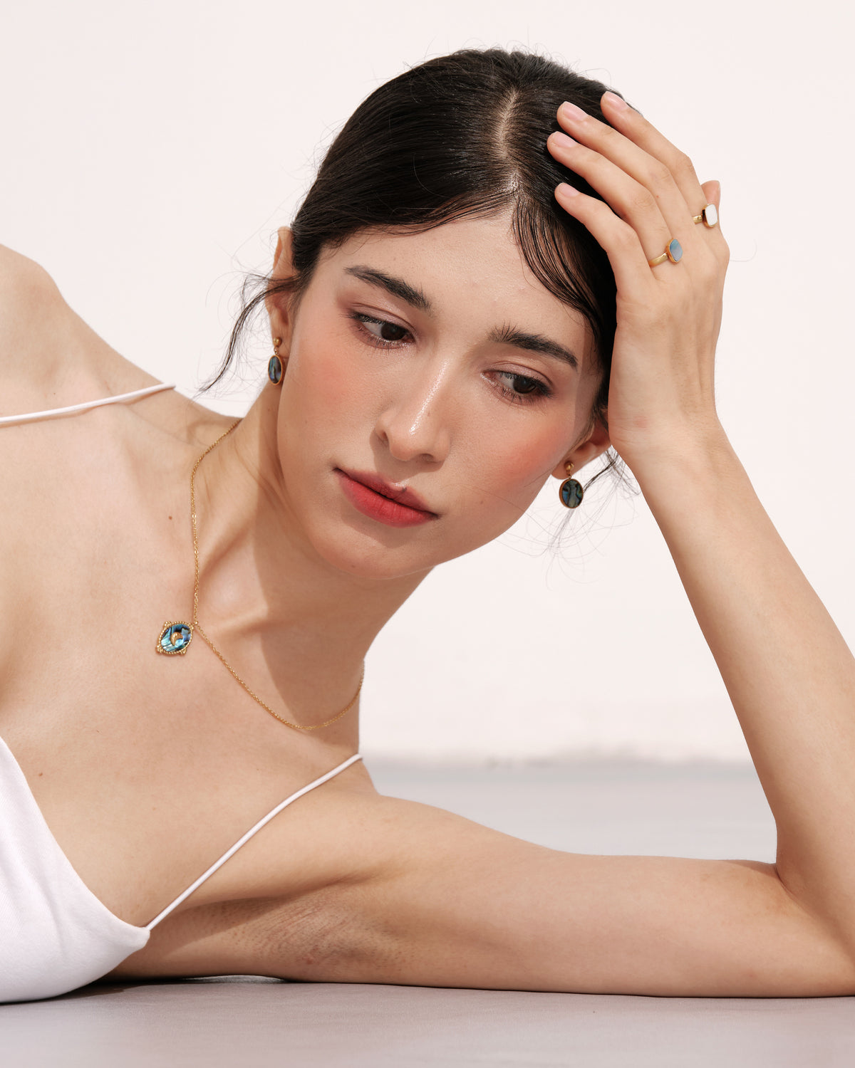 Model wearing the Tidal Stone Pendant Necklace with coordinating abalone earrings