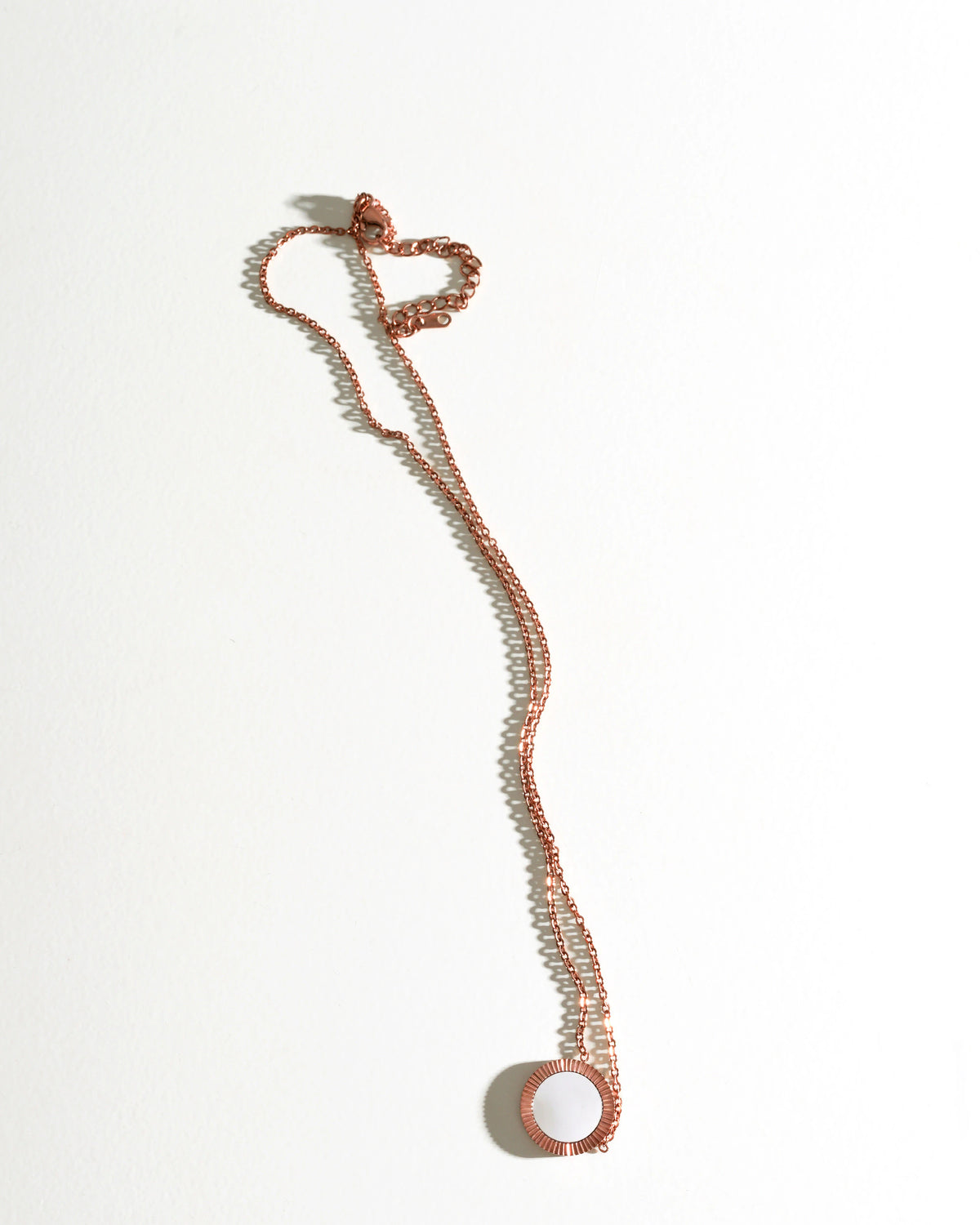 Full view of the Rose Reflection Pendant Necklace laid vertically