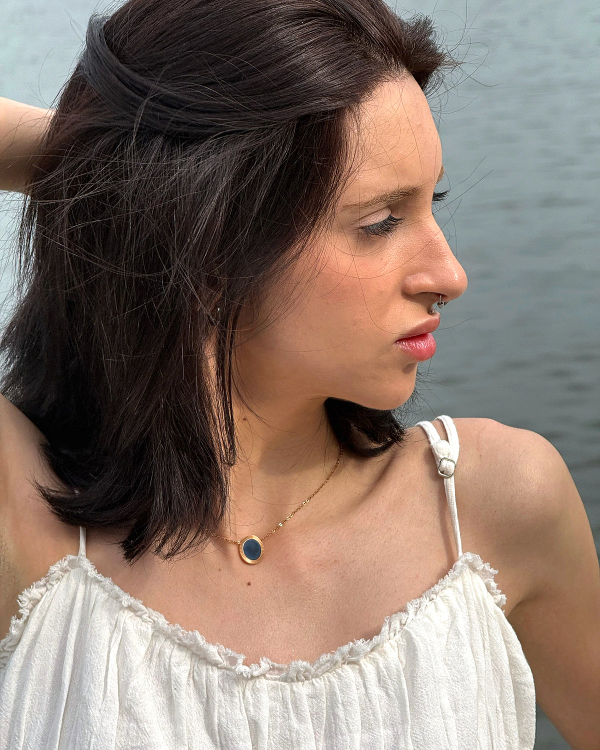 Model wearing the Rose Reflection Pendant Necklace outdoors