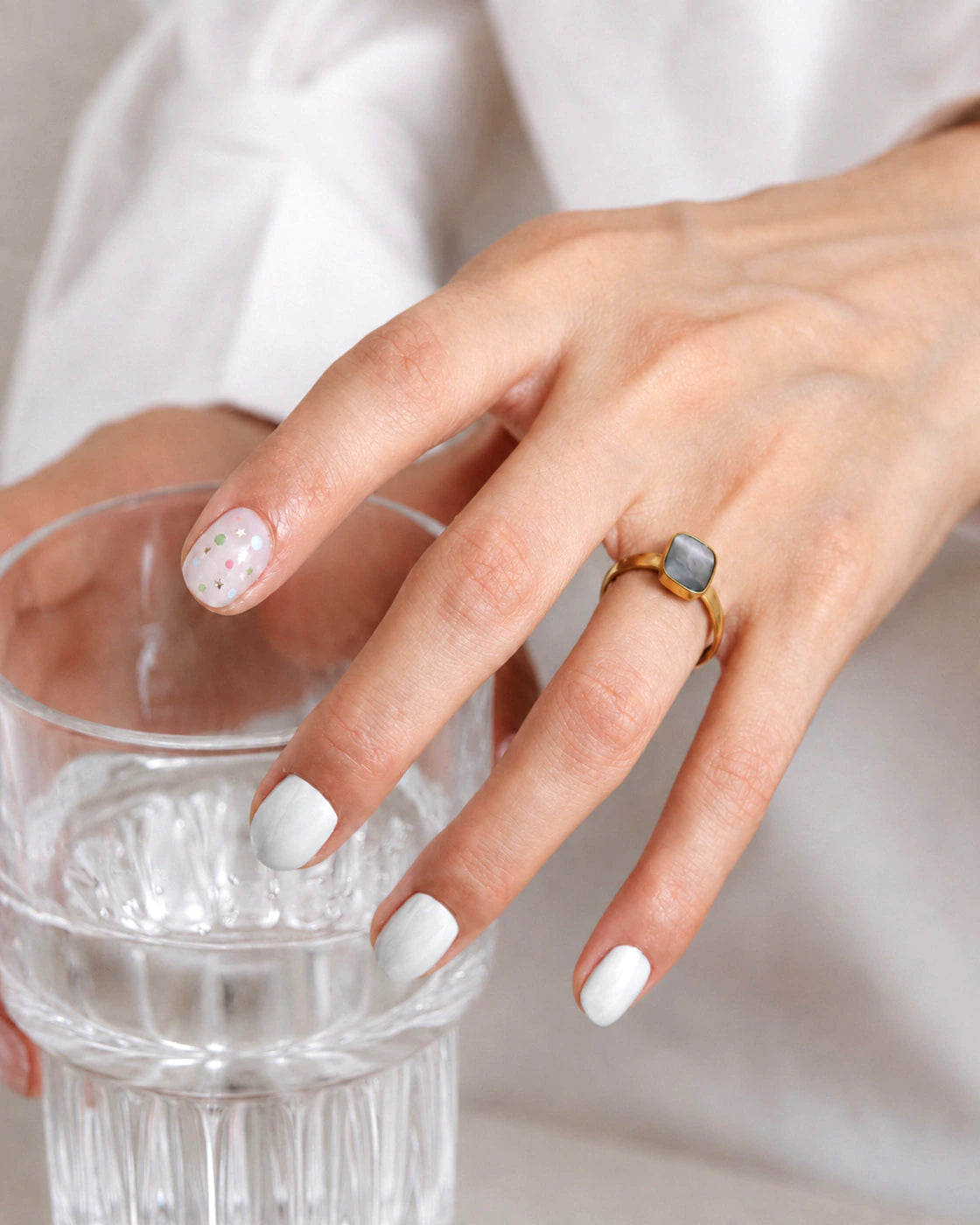 Model wearing the Mist Tide Ring while holding a glass