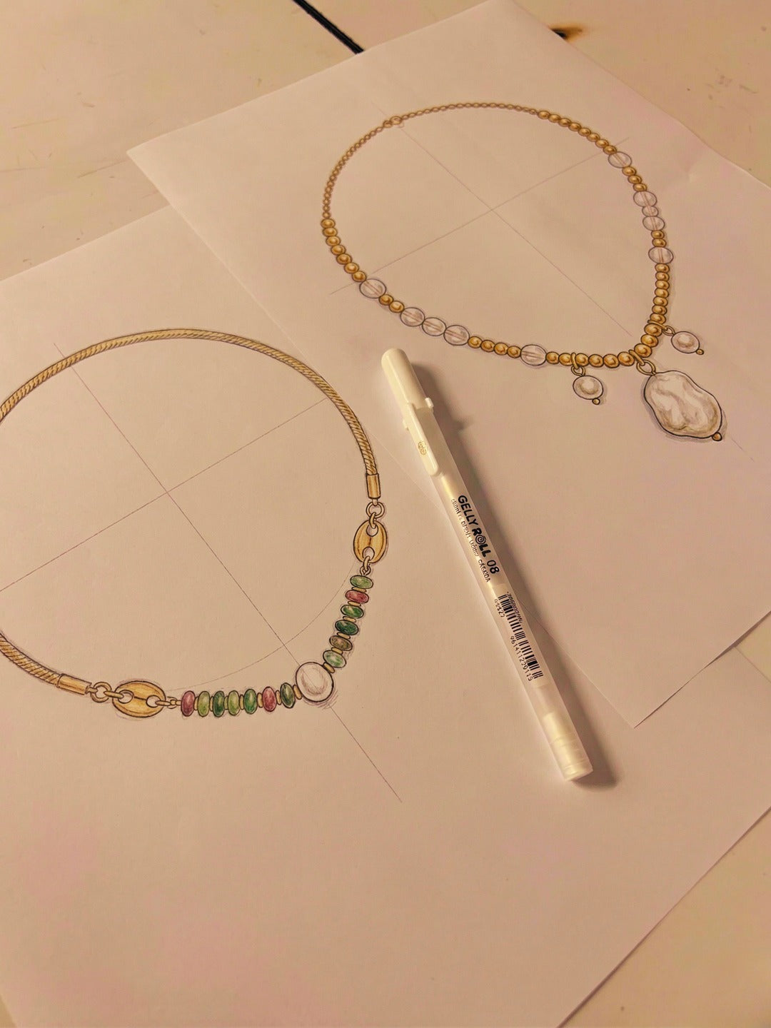 Hand-drawn jewelry sketches laid across a studio desk.